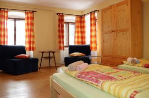 a bedroom with two beds and two chairs and windows at Chalupa Hojna Voda in Horní Stropnice