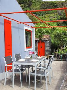 - une table et des chaises blanches sur la terrasse dans l'établissement Casinha de Nesquim, à Calheta de Nesquim