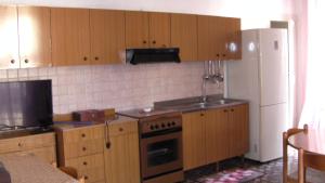 a kitchen with wooden cabinets and a stove and a refrigerator at Appartamento Gioiosa Marea in Gioiosa Marea