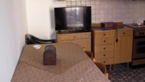 a room with a table and a television and a table with a shoe at Appartamento Gioiosa Marea in Gioiosa Marea