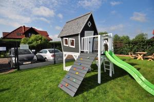 a play house with a slide in a yard at Piaskowy 2 in Jantar