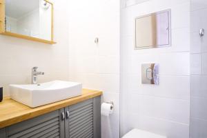 ein weißes Badezimmer mit einem Waschbecken und einem Spiegel in der Unterkunft Dream Stay - Authentic Studio near Seaplane Harbour in Tallinn
