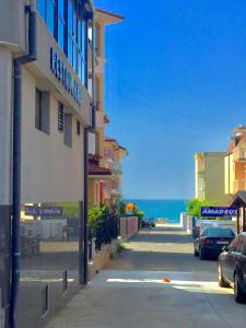 una calle con un edificio y el océano en el fondo en Boutique Hotel Royal, en Nesebar
