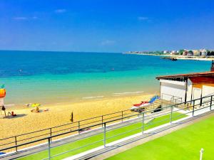 a beach with people laying on the sand and the ocean at Boutique Hotel Royal in Nesebar