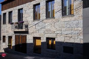 a stone building with a bunch of windows at L'atelier Apartments (Pintura) in Guimarães