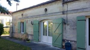 a building with green shutters and a door at La Petite Auberge in Comps