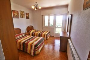 a bedroom with two beds and a window at Casa Ardaña in Carballo