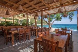 a restaurant on the beach with tables and chairs at Puerto Seaside Rooms in Akhladherí