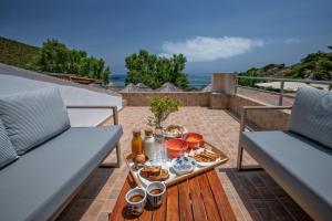a tray of food on a table on a patio at Puerto Seaside Rooms in Akhladherí +74 photos