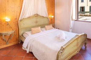 1 dormitorio con 1 cama blanca grande con dosel en Ca' Dinora Appartamenti, en Bardolino