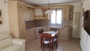 a kitchen with a table and chairs and a couch at Alloggio Ca' dei Frati in Carceri