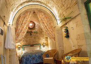 a bedroom with a bed and a stone wall at Relais Santa Maria in Martina Franca