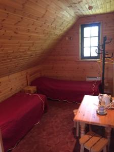 a bedroom in a log cabin with a bed and a table at Laane Pansion in Käsmu