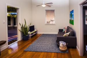 a living room with a couch and a fan at Kenilworth Cottage Barcaldine in Barcaldine