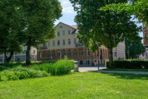 a building in the middle of a park with grass and trees at Appartment Stadtgarten in Tuttlingen