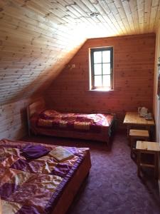 a bedroom with two beds and a window in a log cabin at Laane Pansion in Käsmu