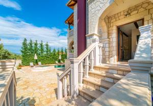 a house with stairs leading to a swimming pool at Fairytale Villa in Lefkada Town