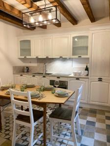 a kitchen with a wooden table and white cabinets at Casa La Margherita in Desenzano del Garda