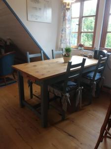 una mesa de madera con 2 sillas y una mesa de madera con en Ferienwohnung Warderhof, en Sandstedt
