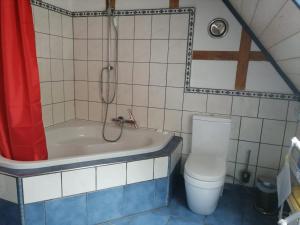 e bagno con vasca, servizi igienici e doccia. di Ferienwohnung Warderhof a Sandstedt