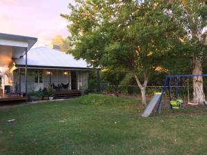 a playground in a yard next to a house at Kenilworth Cottage Barcaldine in Barcaldine