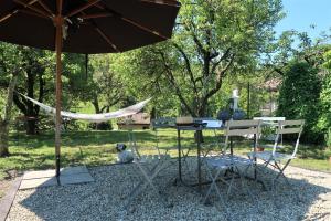 a table and chairs and a hammock in a park at La casa in collina in Bellagio