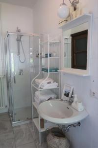 une salle de bain blanche avec un lavabo et une douche dans l'établissement La casa in collina, à Bellagio