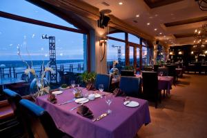 a dining room with tables with purple table cloth at Hotel Tumski in Płock