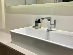 a bathroom sink with a faucet and two bottles on it at Sea View- Easy Home Booking in Nice