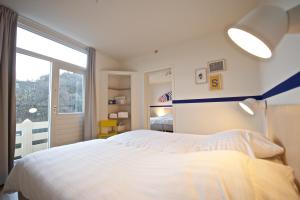 a bedroom with a white bed and a large window at Sonnevanck Wijk aan Zee in Wijk aan Zee +37 photos