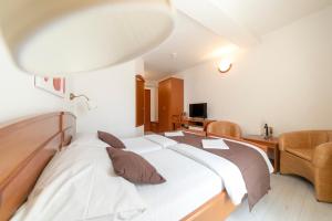 a bedroom with a large bed and a chair at Hotel Hygge in Biograd na Moru