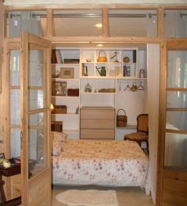 a bedroom with a bed and shelves at Mas Du Petit Claux in Barbentane