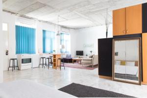 a living room with a kitchen and a living room with a couch at Concierge Downtown in Athens