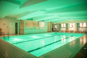 a large swimming pool in a building at Fletcher Hotel-Restaurant Klein Zwitserland in Heelsum