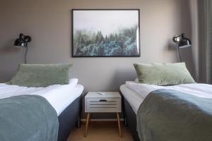 - 2 lits dans une chambre avec une photo sur le mur dans l'établissement Hotel B&B Gränden, à Skellefteå