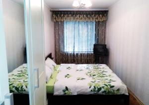 a small bedroom with a bed and a window at Уютная, благоустроенная 2-комнатная квартира, WiFi in Bobruisk