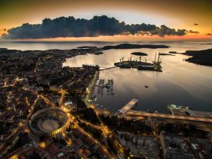 an aerial view of a city with a harbor at night at Apartman Studio in Pula