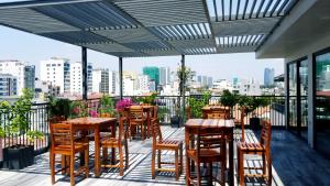 a patio with tables and chairs on a balcony at Infinity Pool - 5 min walk to beach - Sekong Apartment in Da Nang