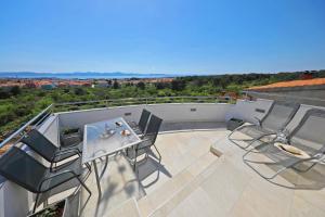 d'une terrasse sur le toit avec une table et des chaises. dans l'établissement Magic Blue Sky Apartment, à Zadar