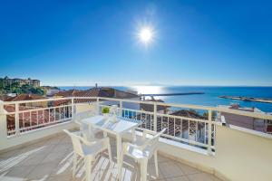a balcony with a table and chairs and the ocean at Villa Margarita in Limenaria
