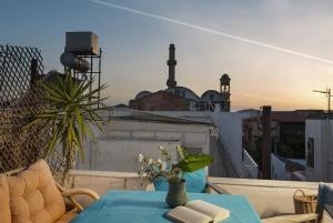a table on a balcony with a view of a city at House Erofili in Chania