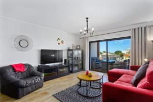 a living room with two red couches and a table at Casa Saura in Alvor