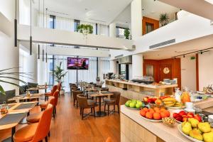 um restaurante com mesas, cadeiras e frutas em exposição em Hotel Fagus by Aycon em Budva