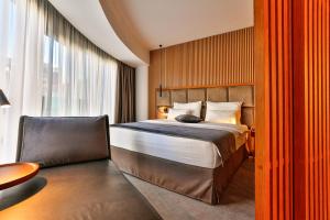 a bedroom with a large bed and a large window at Hotel Fagus by Aycon in Budva