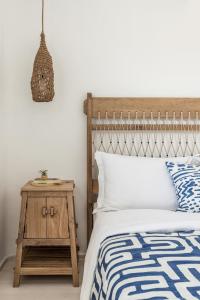 a bedroom with a bed with a wooden headboard and a side table at Saluti Da Stampalia in Astypalaia Town