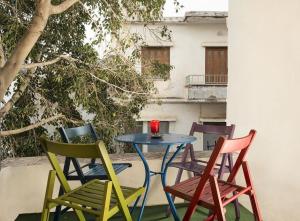 four chairs and a table with a red candle on it at House Erofili in Chania