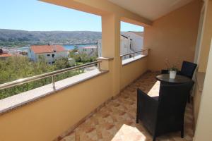 einen Balkon mit einem Tisch und Stühlen sowie Aussicht in der Unterkunft Family Apartments House Damir in Pag