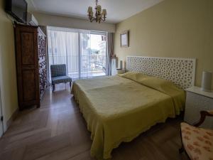 1 dormitorio con cama y ventana grande en LE LIBECIO - FAMILIALE ET CONFORTABLE, en Antibes