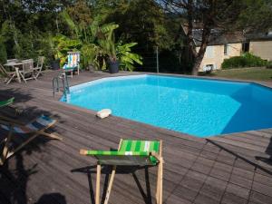 uma piscina azul com uma cadeira e uma mesa em le breuil em Sarlat-la-Canéda