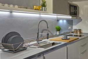 a kitchen with a sink and a dish drying rack at San Giorgio 2 in Bologna